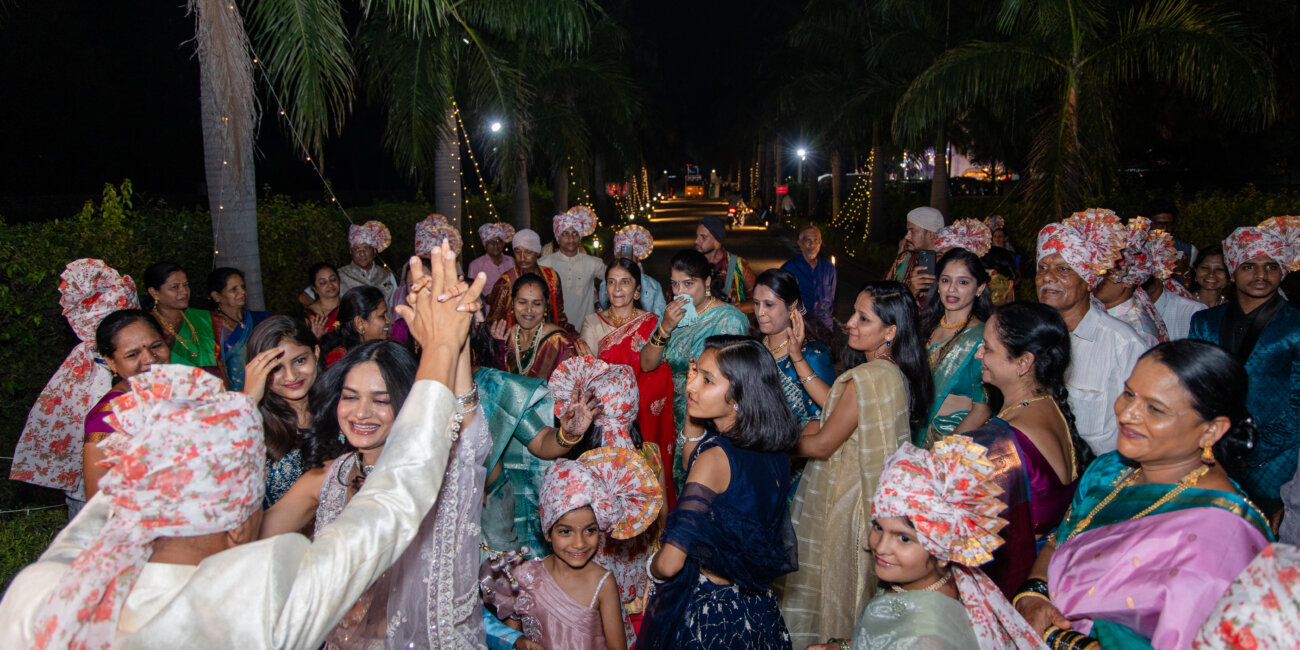 A North Indian groom in a regal sherwani makes his vibrant entry on surrounded by family and friends dancing joyfully.