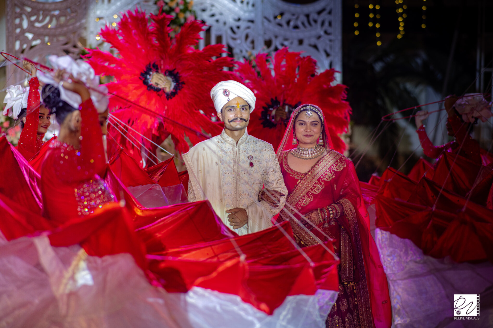 n bride and groom walk hand in hand onto a beautifully decorated wedding stage, radiating joy and elegance.