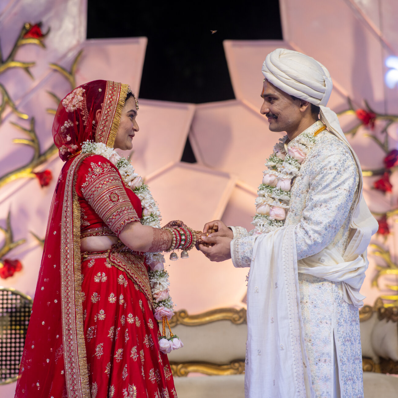 groom delicately places a shimmering ring on the bride’s finger during the wedding ceremony, capturing a moment of love and commitment.