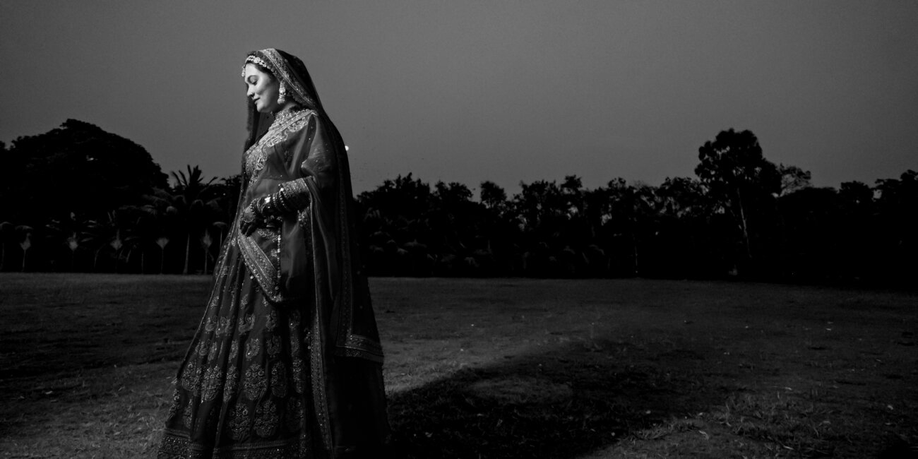 A North Indian bride in a vibrant red lehenga, with intricate gold embroidery and traditional jewelry, during her wedding ceremony.