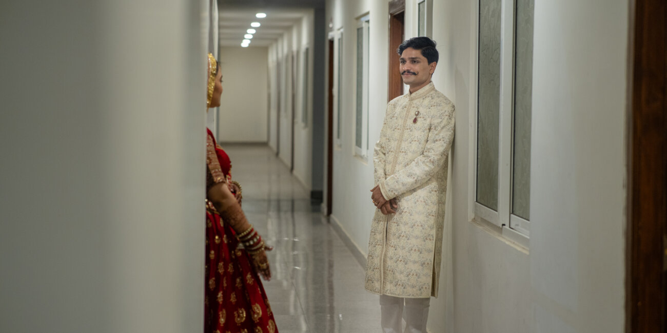 A North Indian bride and groom stand side by side in traditional attire, exuding elegance and joy.