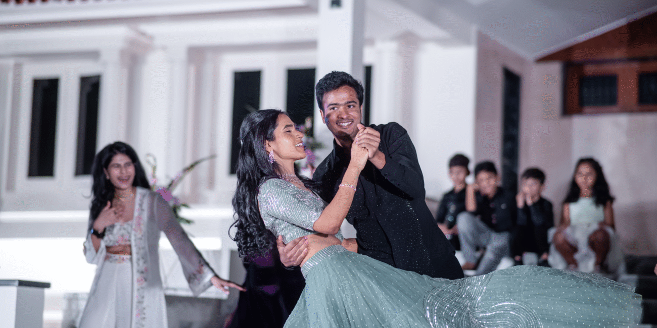 Groom holding the bride after completing a twirl, both smiling and locked in a romantic moment.