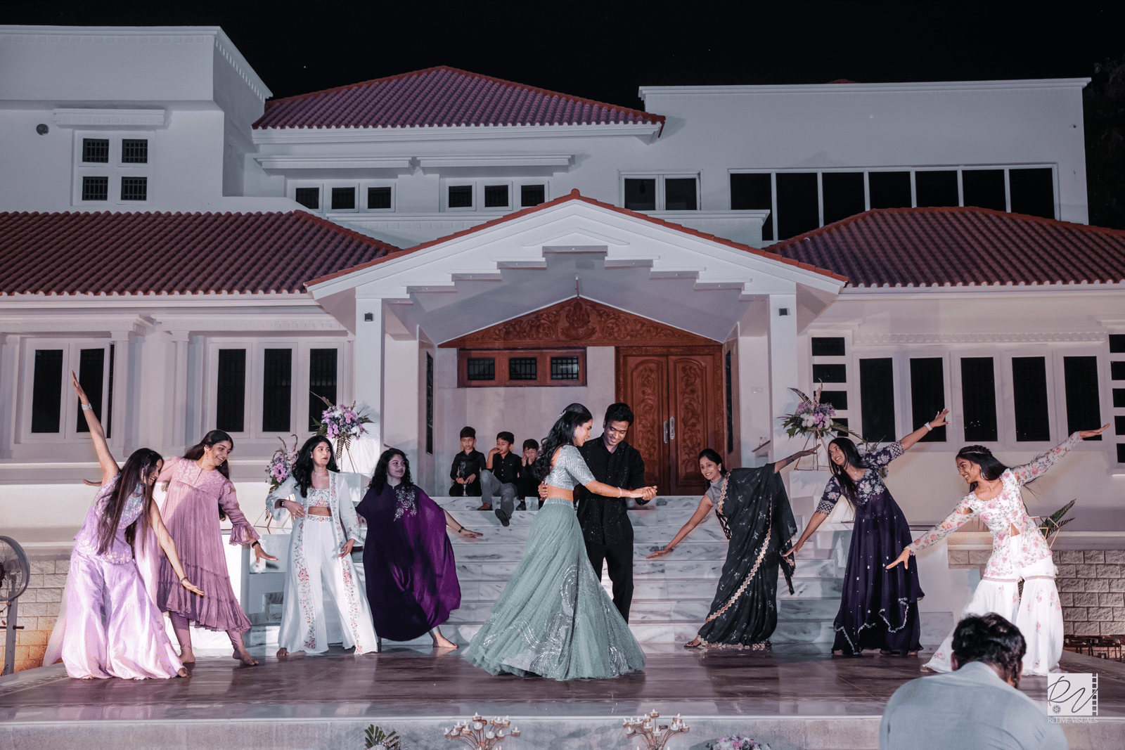 Couple dancing at the center of the dance floor, surrounded by guests dancing joyfully around them.