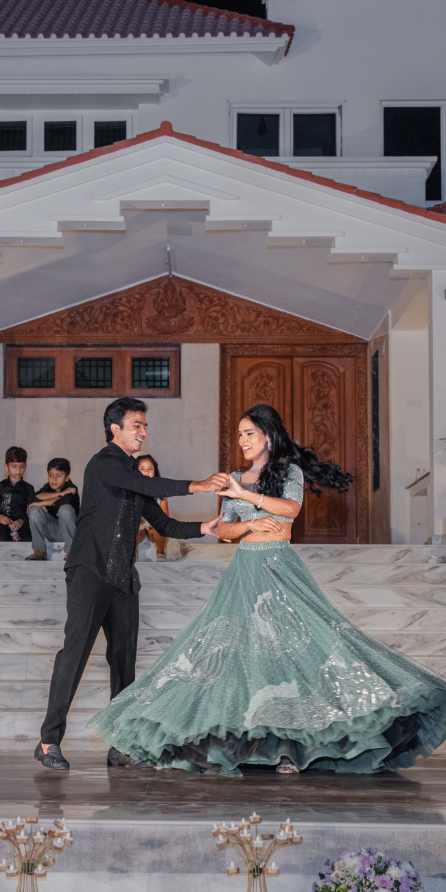 Groom mid-twirl with the bride, her dress flowing as they pause in a graceful dancing moment.