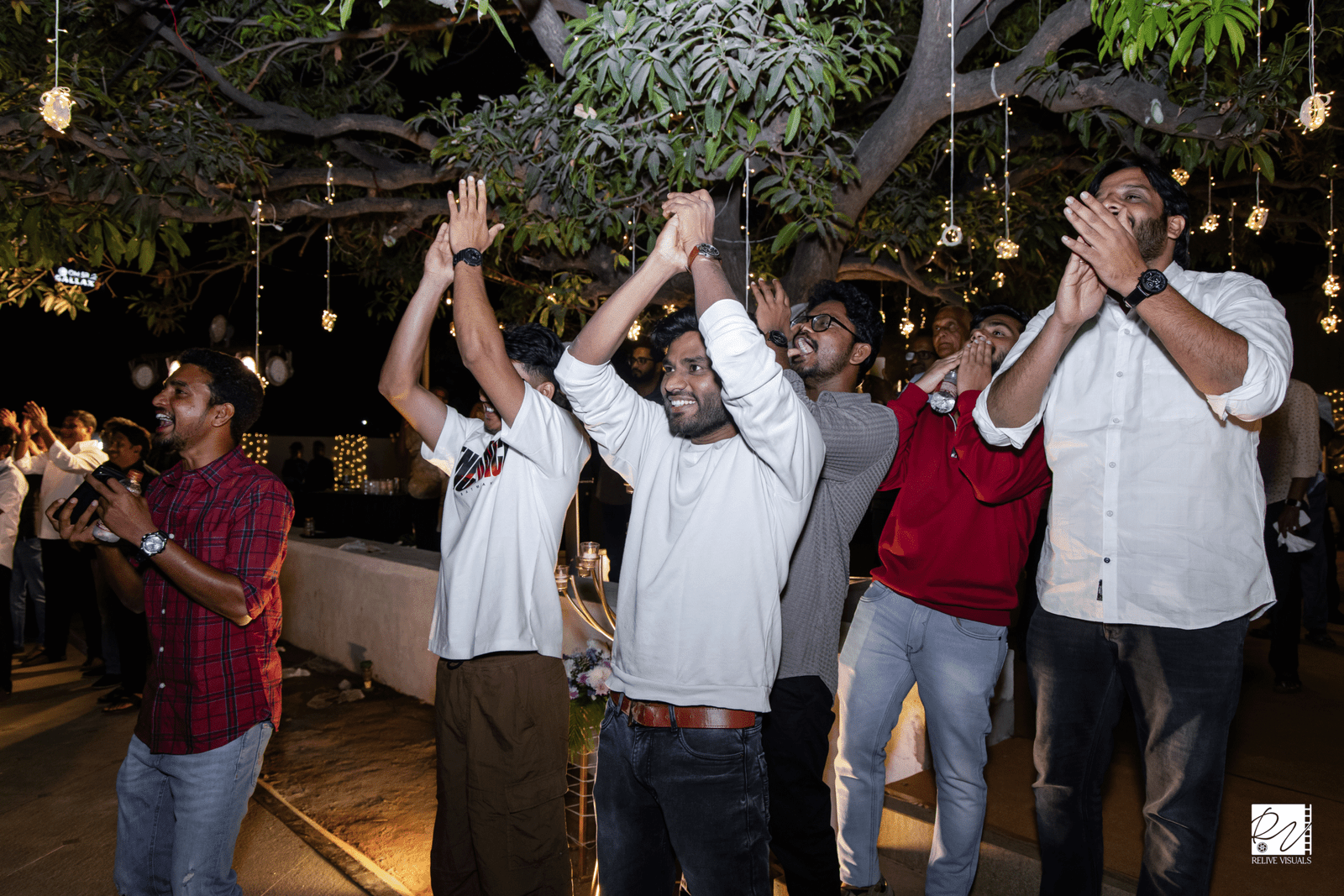 Friends clapping and cheering while the couple dances at their celebration.