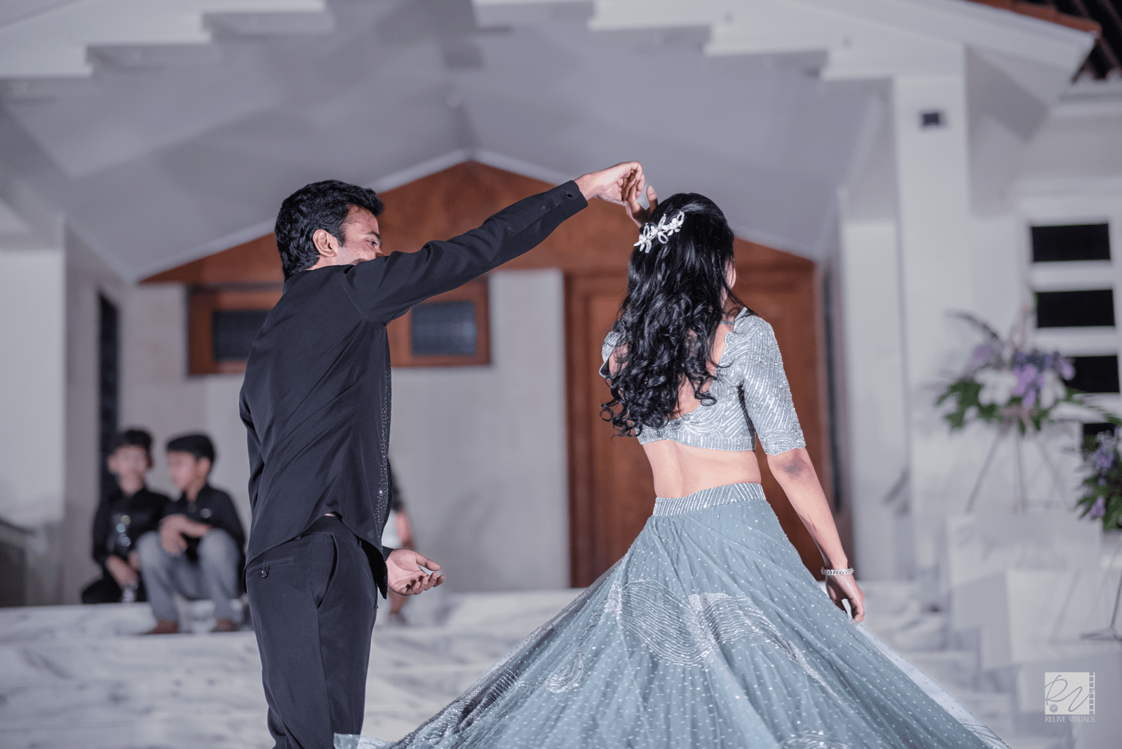 Groom twirling the bride on the dance floor, her dress flowing as they share a joyful moment.
