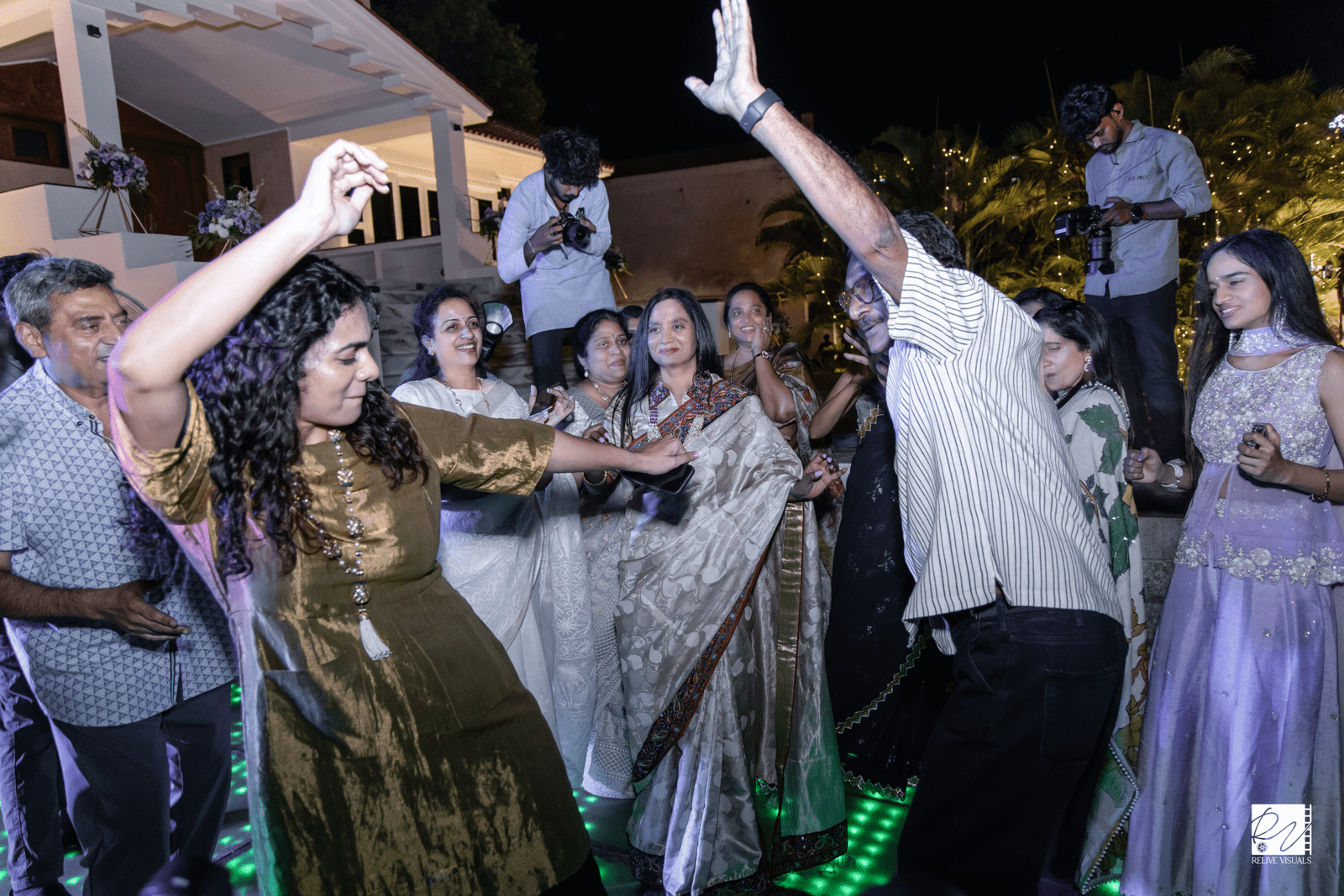 Lively crowd dancing on the dance floor with colorful lights and joyful expressions.
