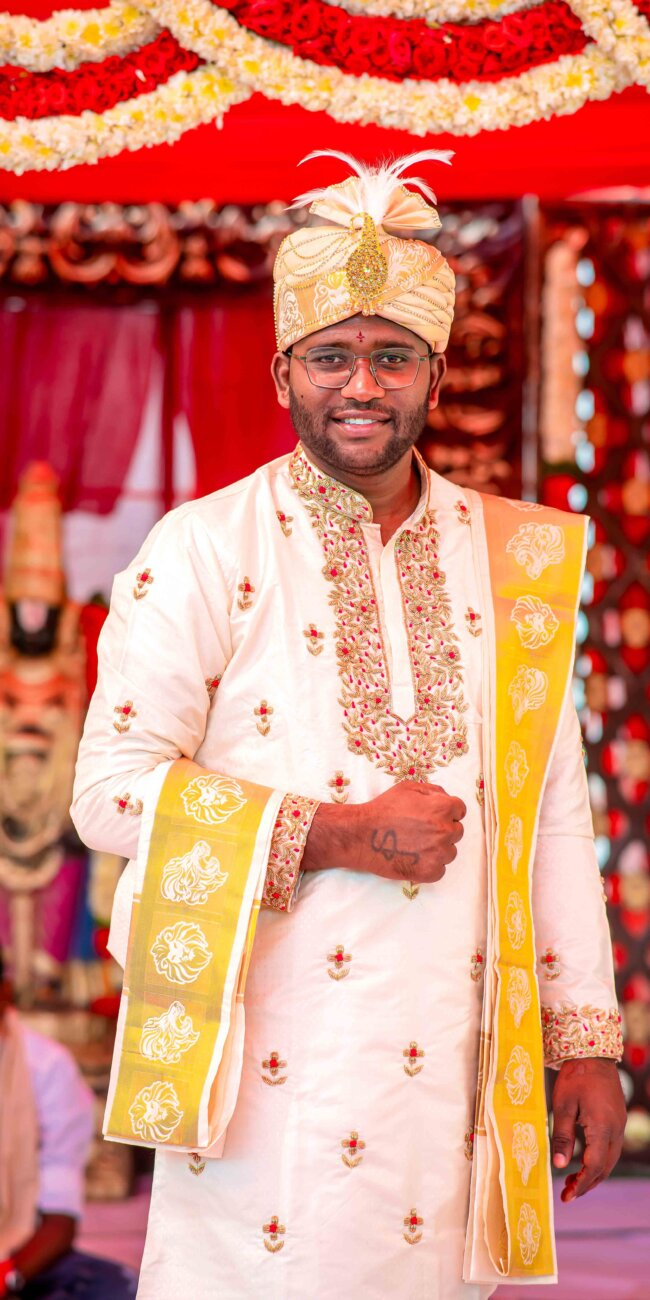 "Telugu groom in traditional attire with panche and kanduva, smiling during wedding ceremony"