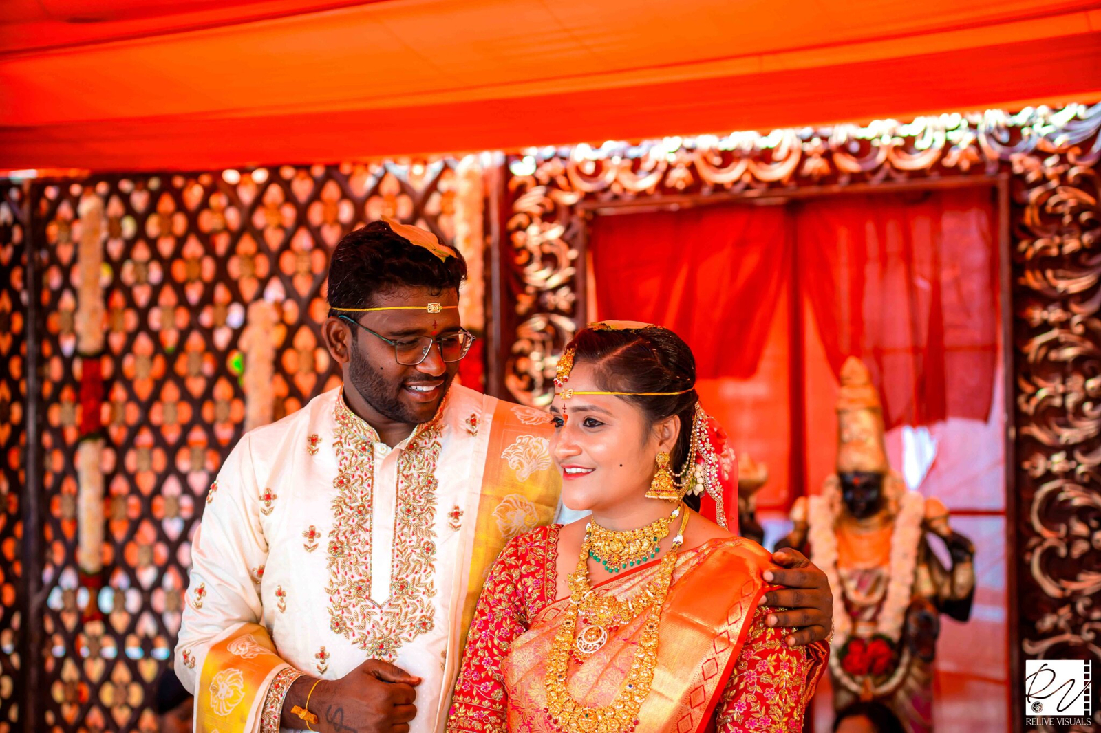 "Telugu bride and groom posing together in traditional wedding attire, smiling gracefully for a portrait"