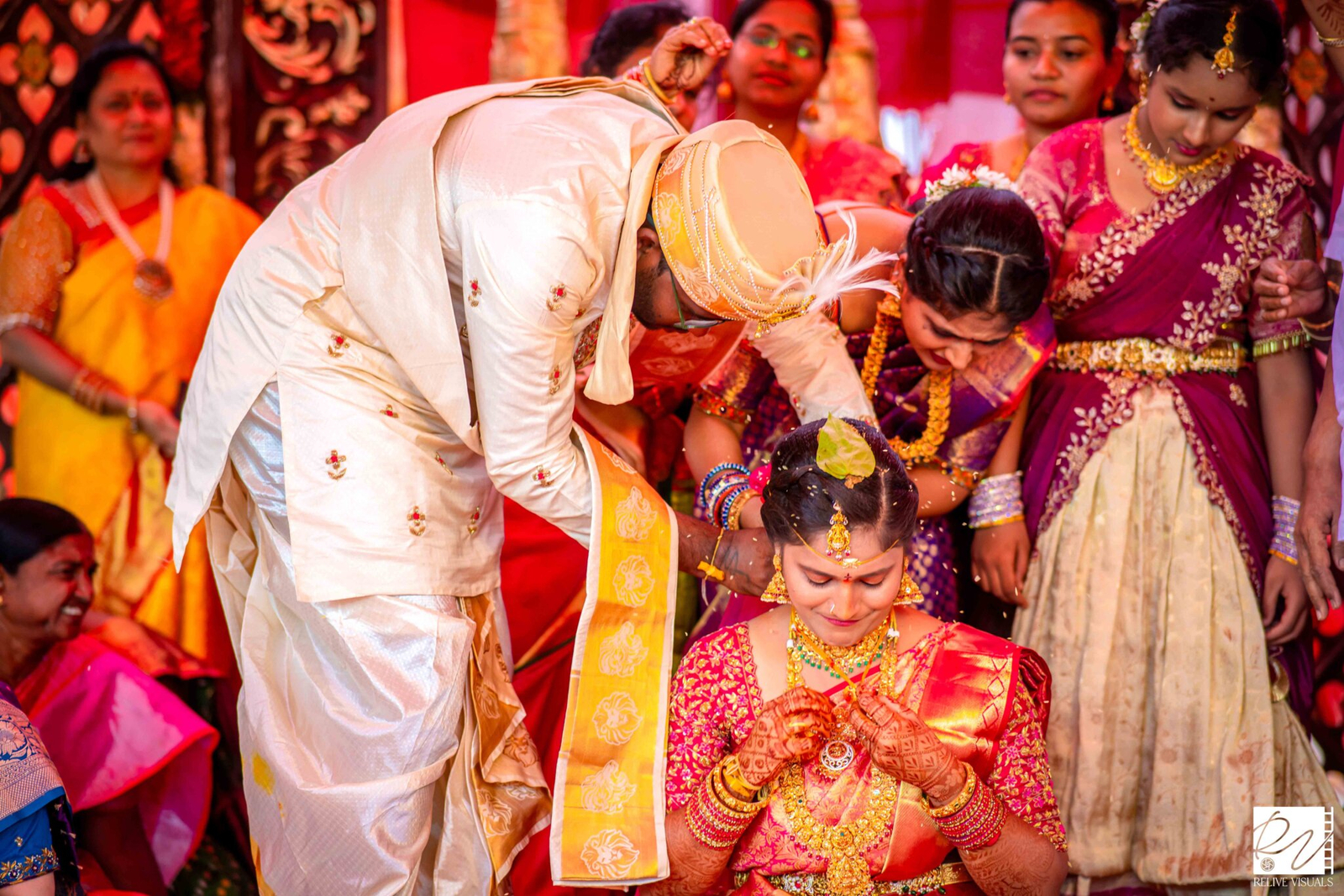 "Telugu groom tying the Thali (Mangalsutra) around the bride’s neck during the wedding ceremony"