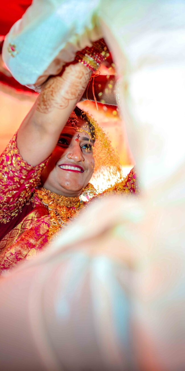 groom pouring Thalambralu on the bride’s head as she smiles gently during the wedding ceremony"