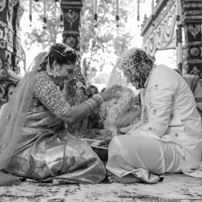 "Telugu bride and groom pouring Thalambralu (turmeric rice) on each other’s heads during the wedding ceremony"