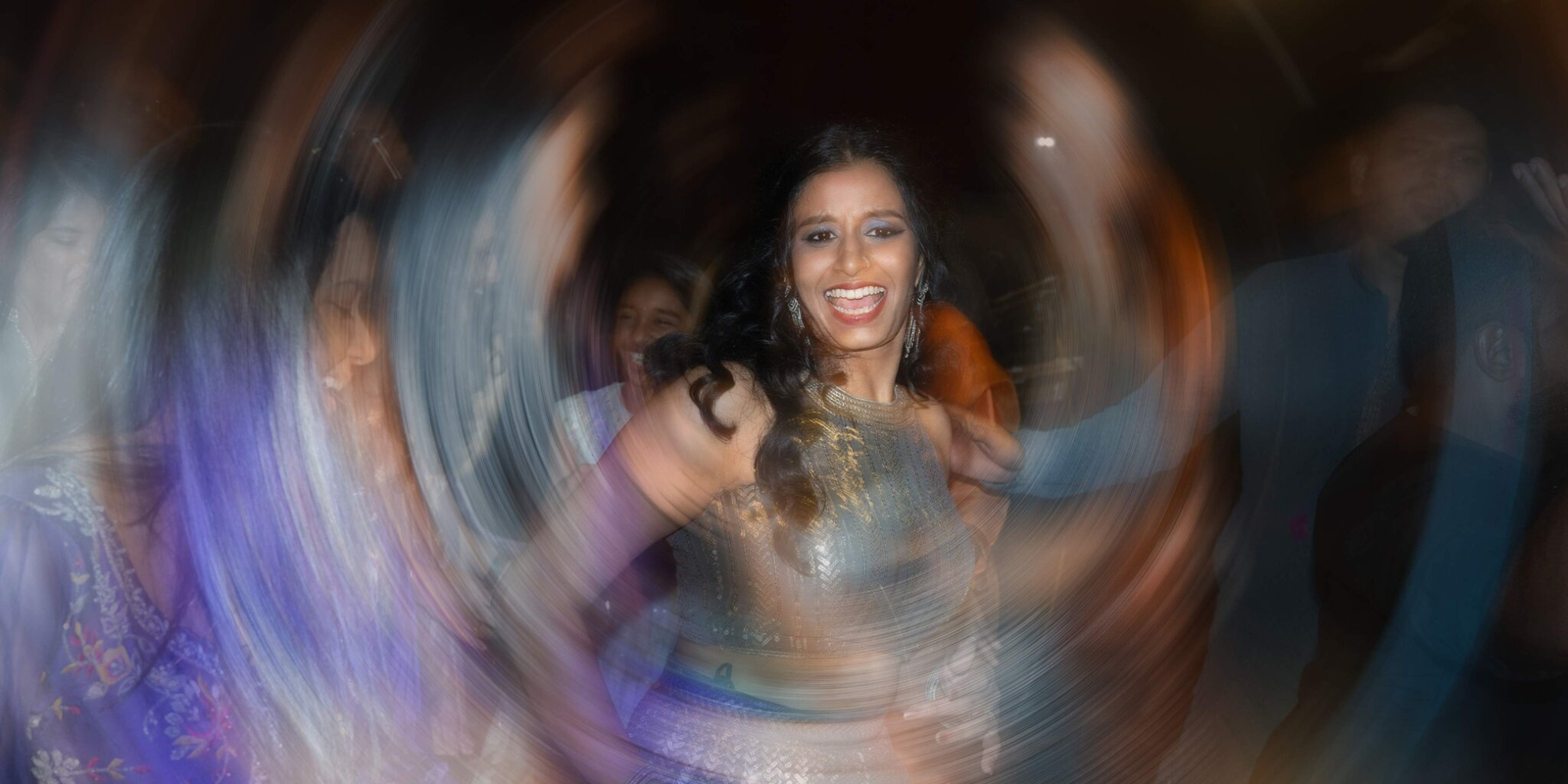 Artistic portrait of the bride during her Sangeet, captured with creative lighting, vibrant colors, and a joyful expression.