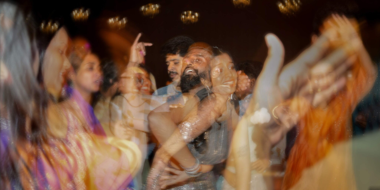 Creative double exposure image from the Sangeet, blending the couple’s portrait with vibrant dance lights and festive décor.