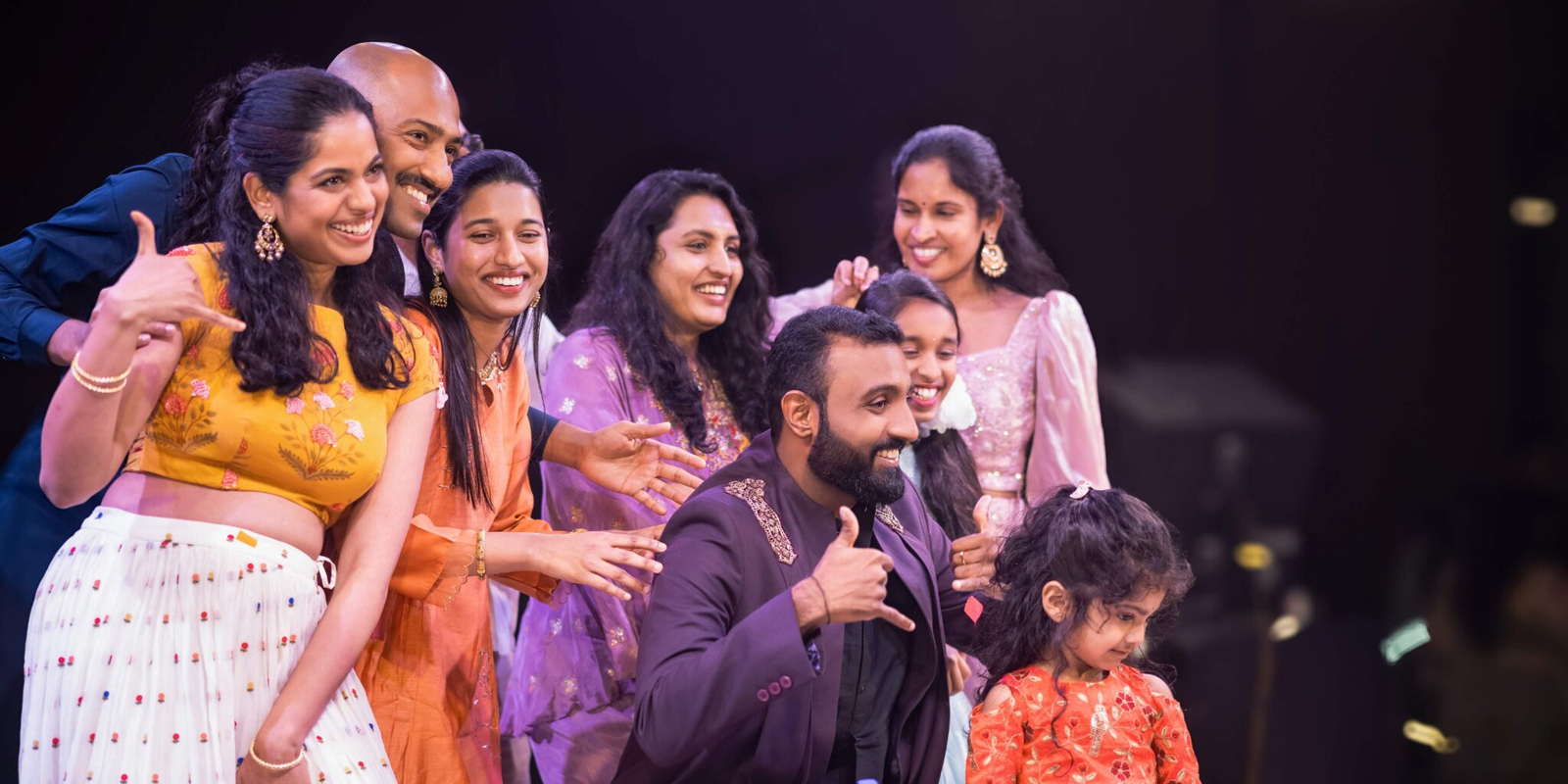 Group shot of the groom dancing with friends and family, all smiling and enjoying the celebration in a lively setting.